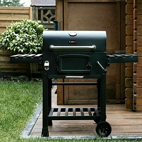 Outdoor charcoal grill on a patio with grass and fence in background.